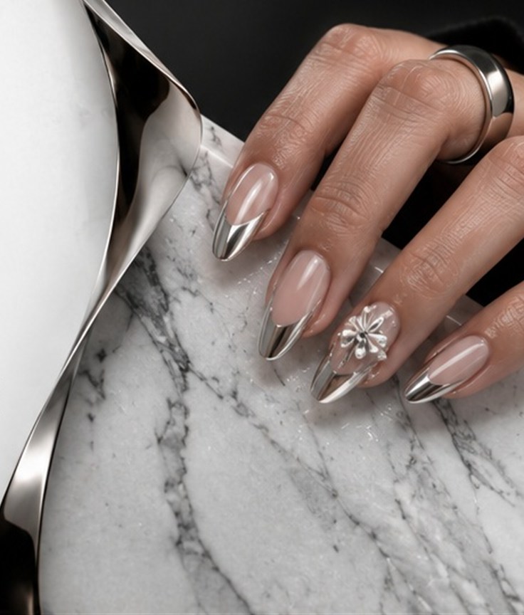 Almond nails with silver chrome tips resting on white marble