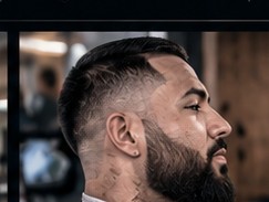 Mid fade with a lined-up beard.