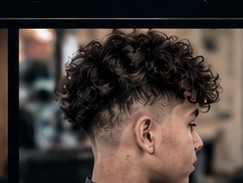 Curly top with a taper fade.