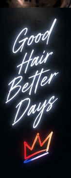 Neon sign reading Good Hair Better Days above a neon crown.