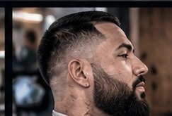 Mid fade with a lined-up beard.