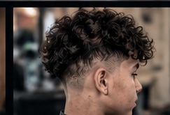 Curly top with a taper fade.