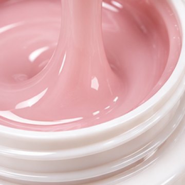 An open jar of pale pink builder gel with a spatula