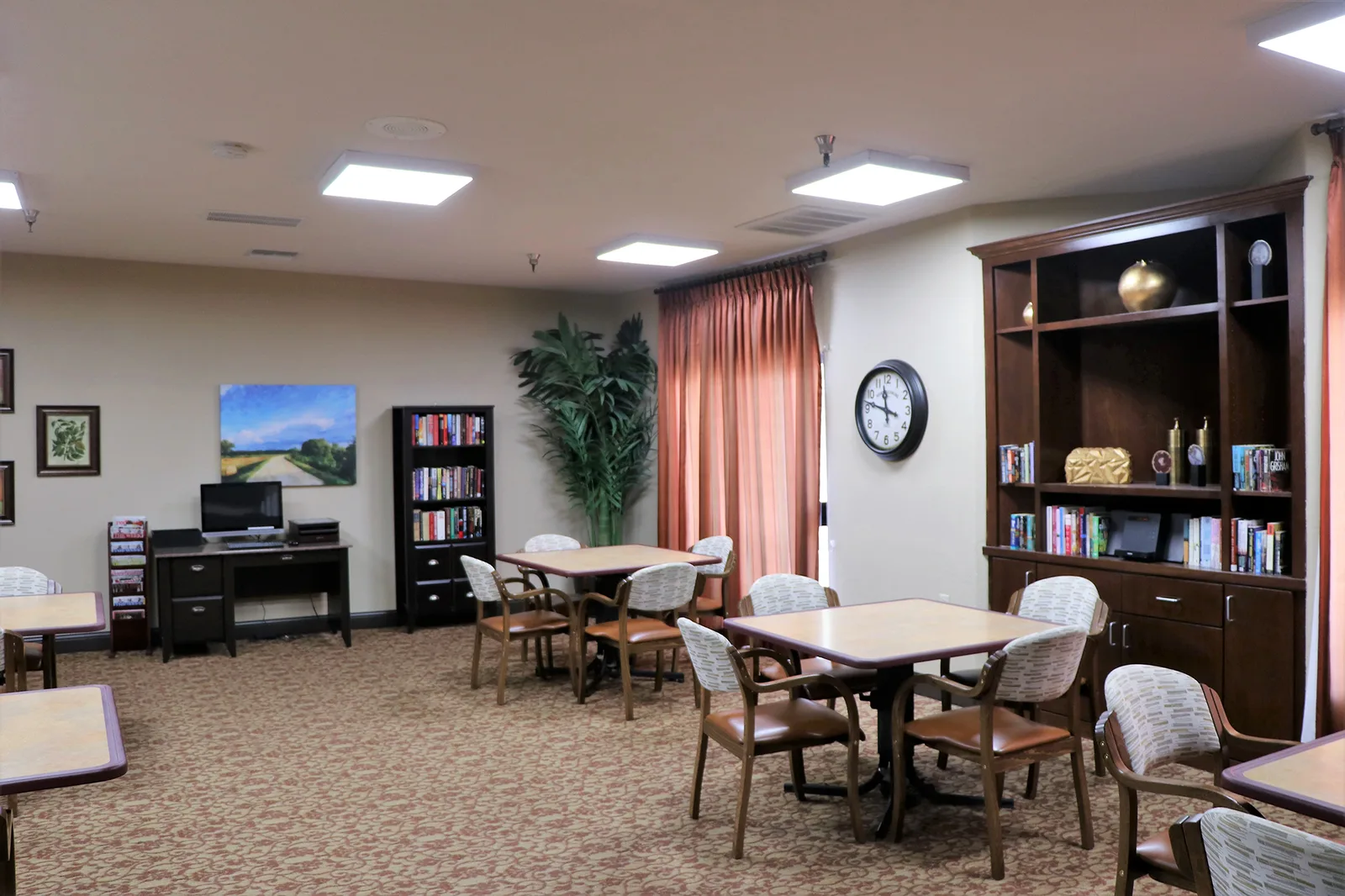 The activity room with tables, bookshelves and natural light
