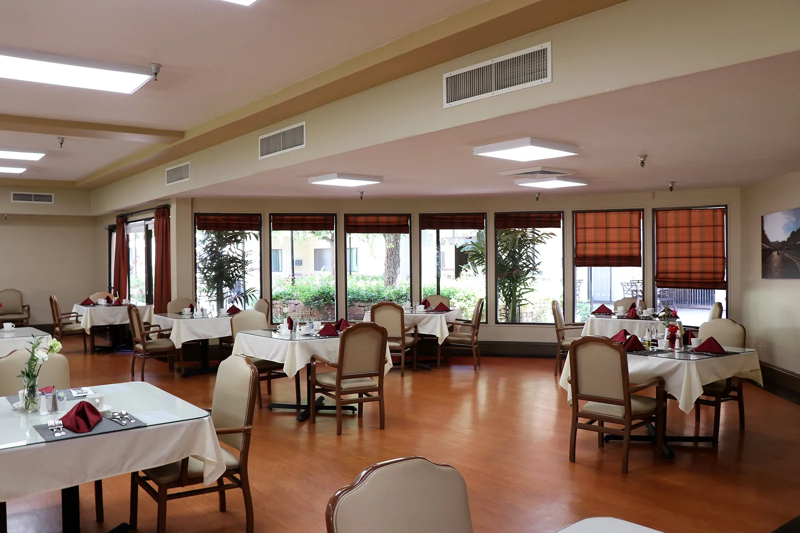 The main dining room with tables set and garden windows