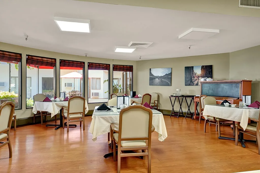 The dining room with tables laid beside the garden windows