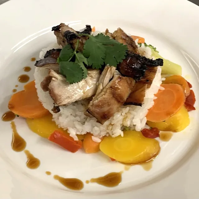 A plated entree of pork with vegetables