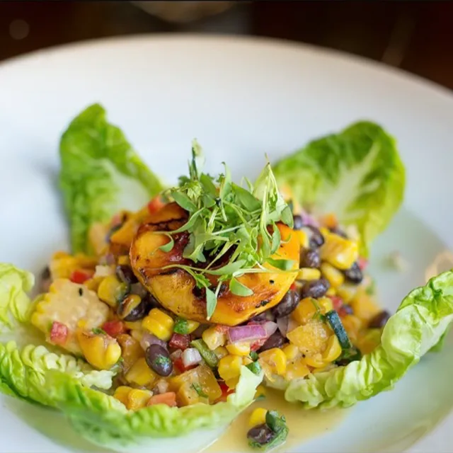 A fresh salad plated in lettuce leaves