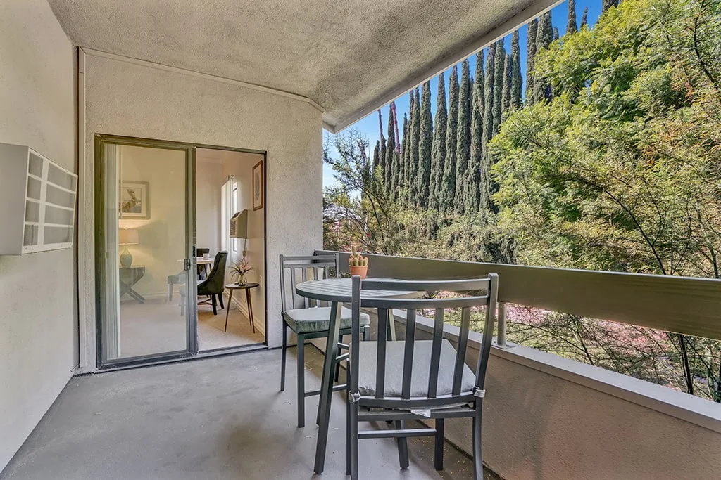 A private balcony with a table and chairs looking onto the garden