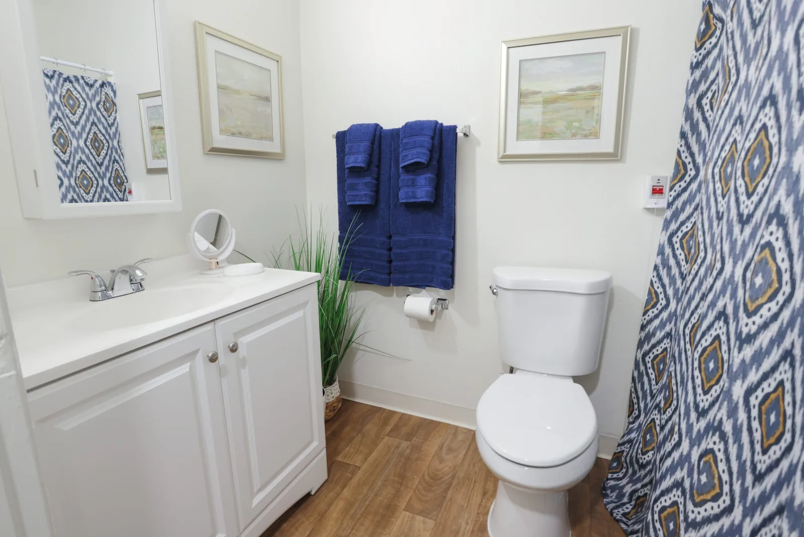 A suite bathroom with vanity, mirror and fresh towels