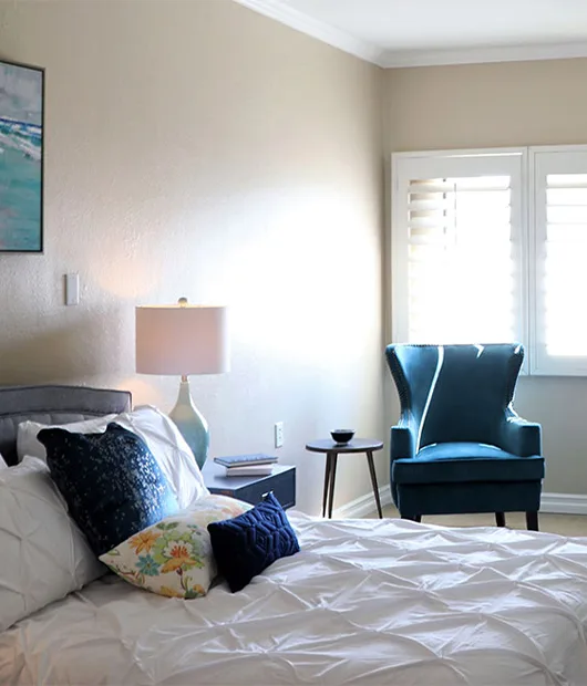 A studio suite with a bed, armchair and window